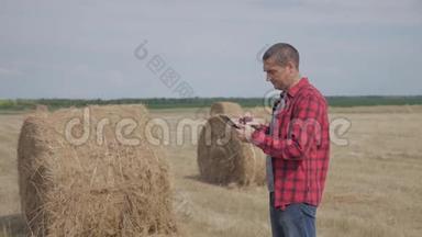 智慧<strong>农业</strong>概念生活方式.. 一名农民工人在<strong>数字</strong>平板电脑上的田野里研究干草堆。 慢慢慢慢